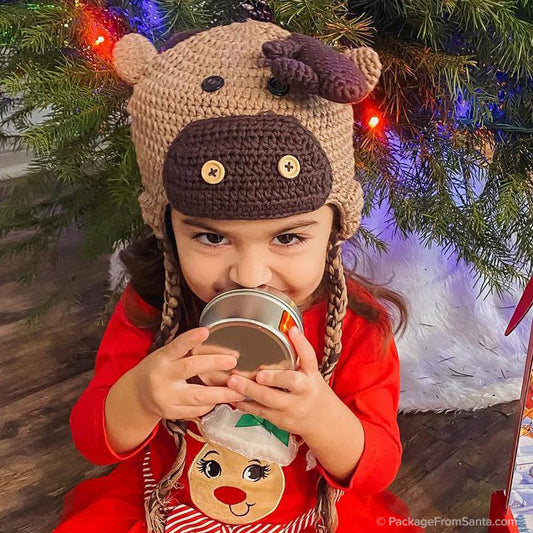 Package From Santa® - Girl wearing Reideer Hat while holding on to her Reindeer Tin that's full of reindeer feed. -Package From Santa®