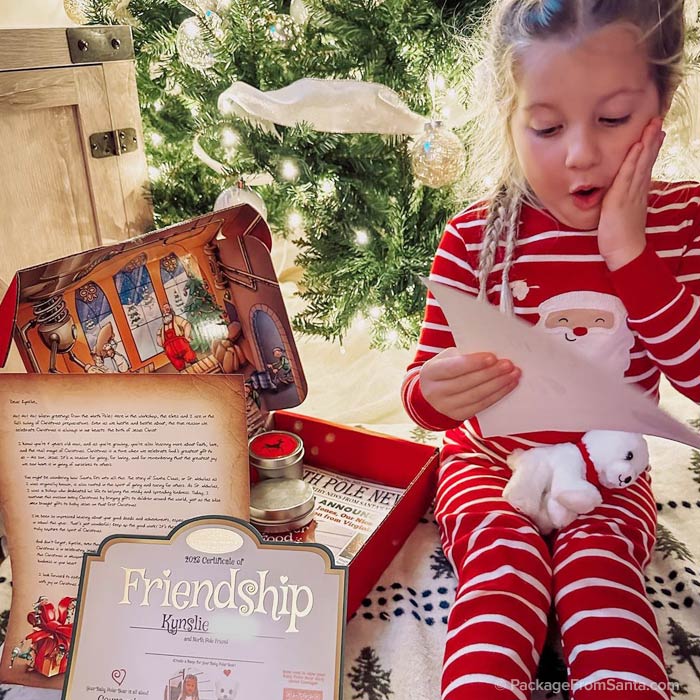 Excited girl opens her personalized Letter from Santa from Package From Santa®!