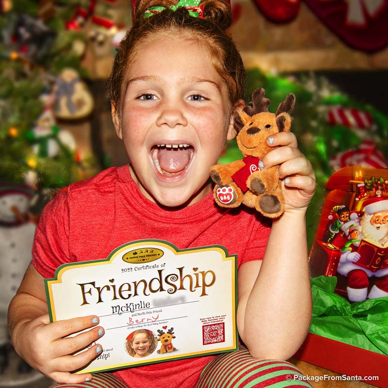 Girl holding baby Reindeer plushie with Freindship Certificate from Package From Santa®